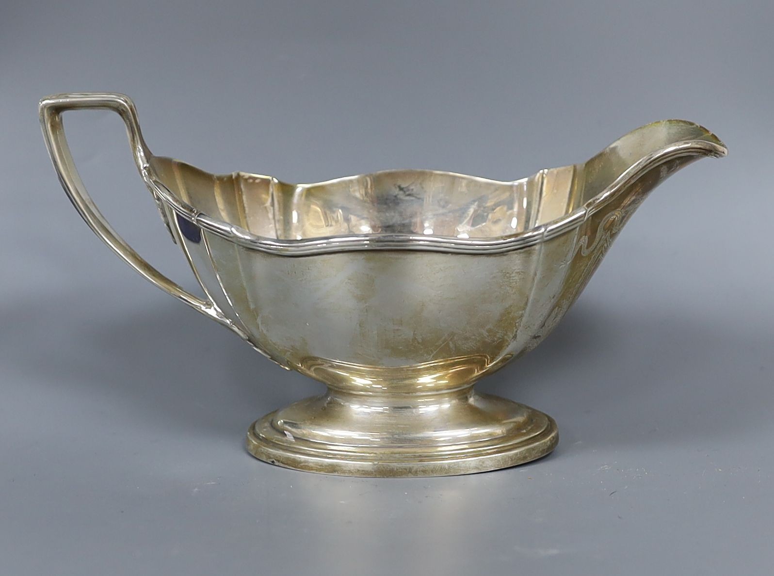 An American sterling sauceboat, a silver cream jug, a modern silver commemorative letter opener and three other items.